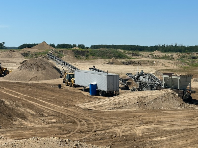 Oversize load transport of a wind turbine part and a pilot vehicle move along rural road.